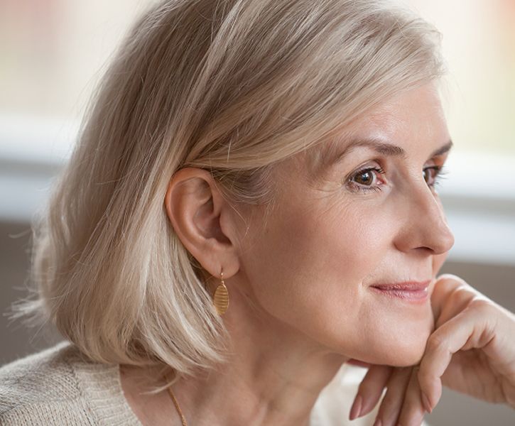 Woman with short blonde hair and earrings.